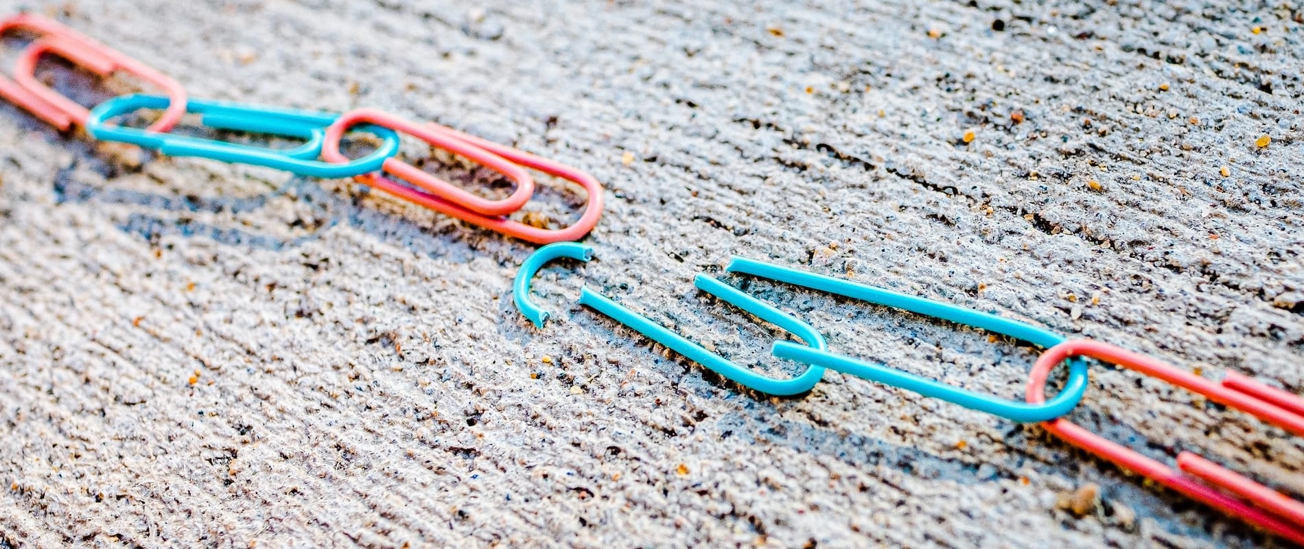 Blue and red linked paper clips with one link broken